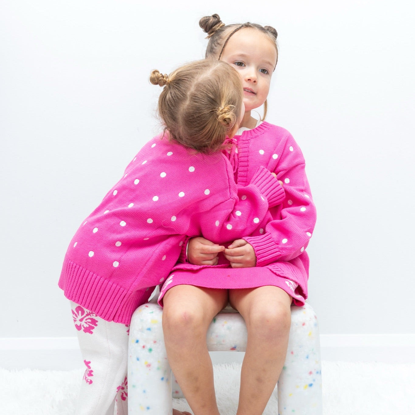 Two girls in matching pink polka dot and hibiscus tie-up cardigans - Dad Dressed Me Tropical Trip