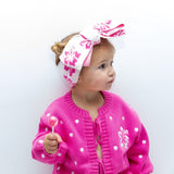 Toddler in pink polka dot tie-up cardi with hibiscus headband - Dad Dressed Me Tropical Trip