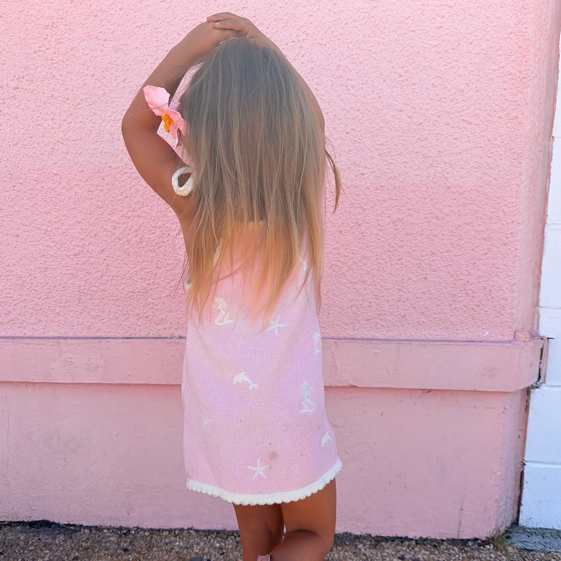 Back view of pink dolphin knit sun dress with scalloped hem