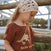 Child leaning on a wooden fence at golden hour wearing the Golden Hour Garden Tee in brown, showing the hand drawn flower and bee print