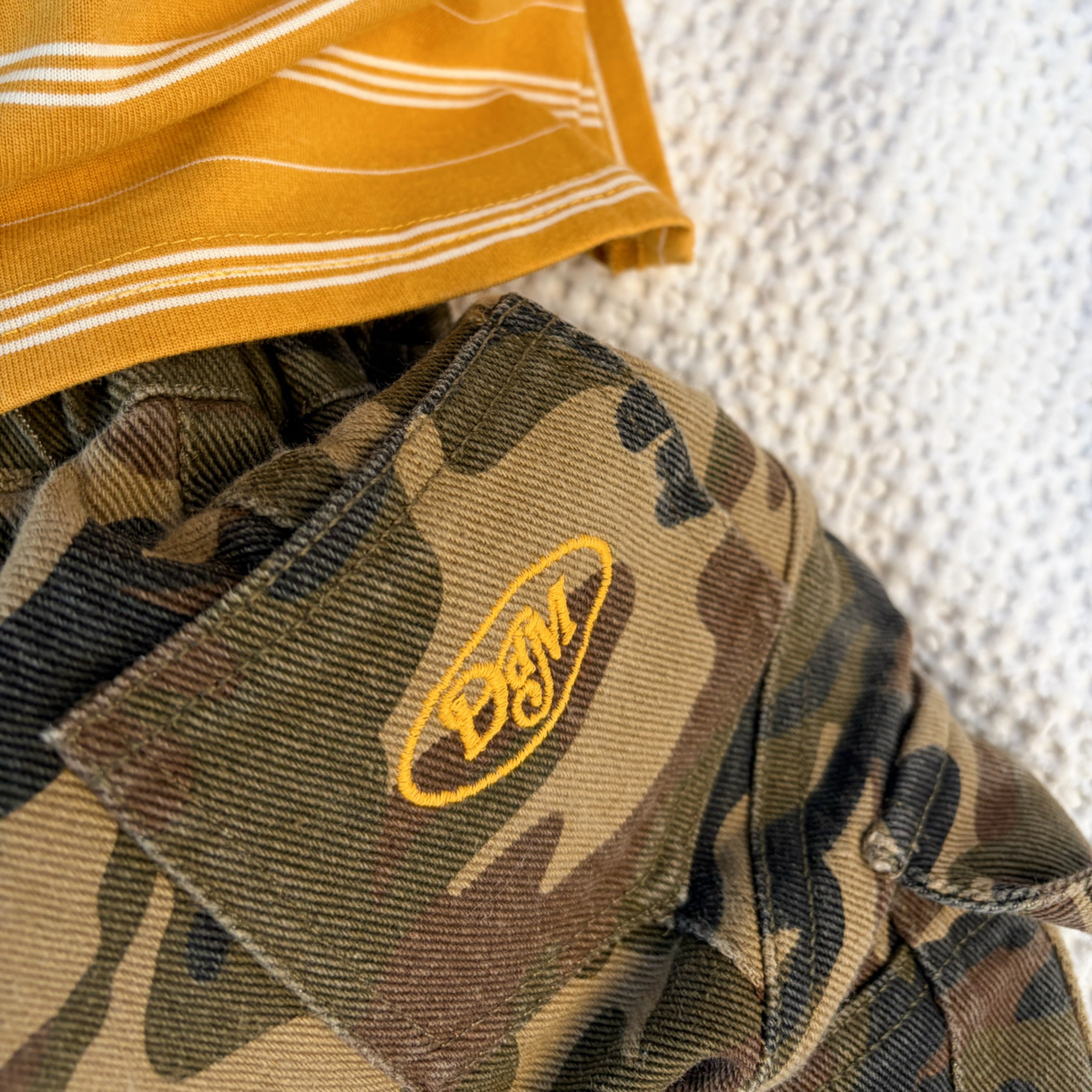 Close up of the Dad Dressed Me logo patch on the Garden Explorer Cargos in cotton camo