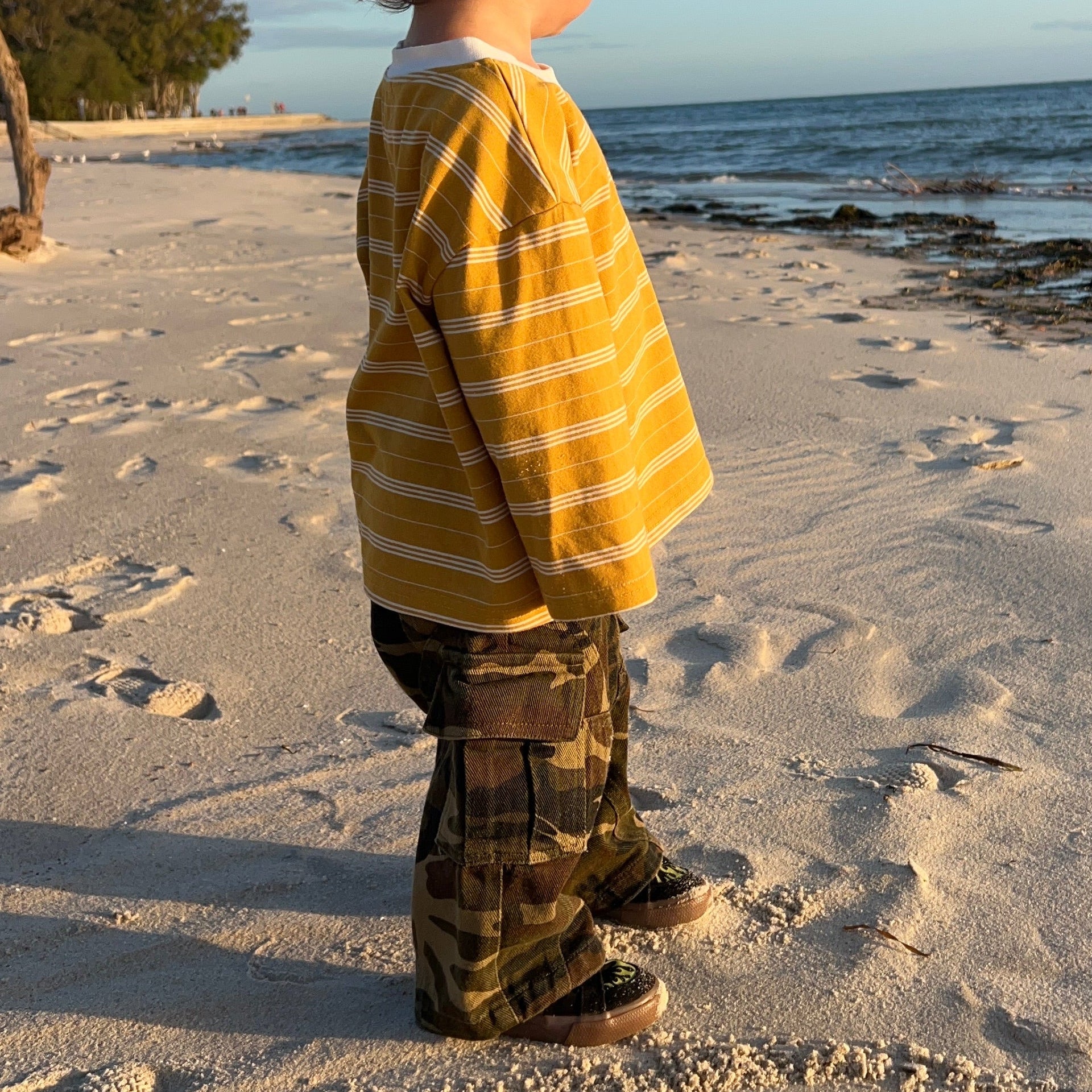 Child on the beach at sunset in the Garden Explorer Cargos and Last Light Long Sleeve