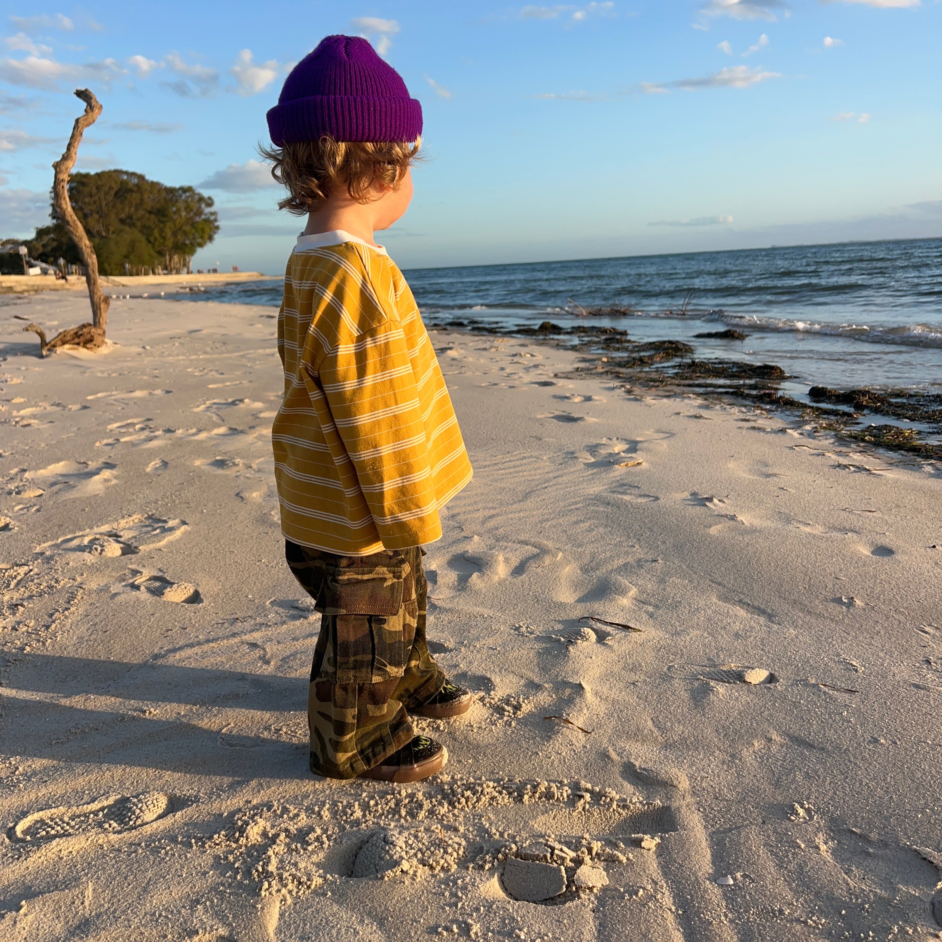 Child on the beach at sunset in the Garden Explorer Cargos and Last Light Long Sleeve