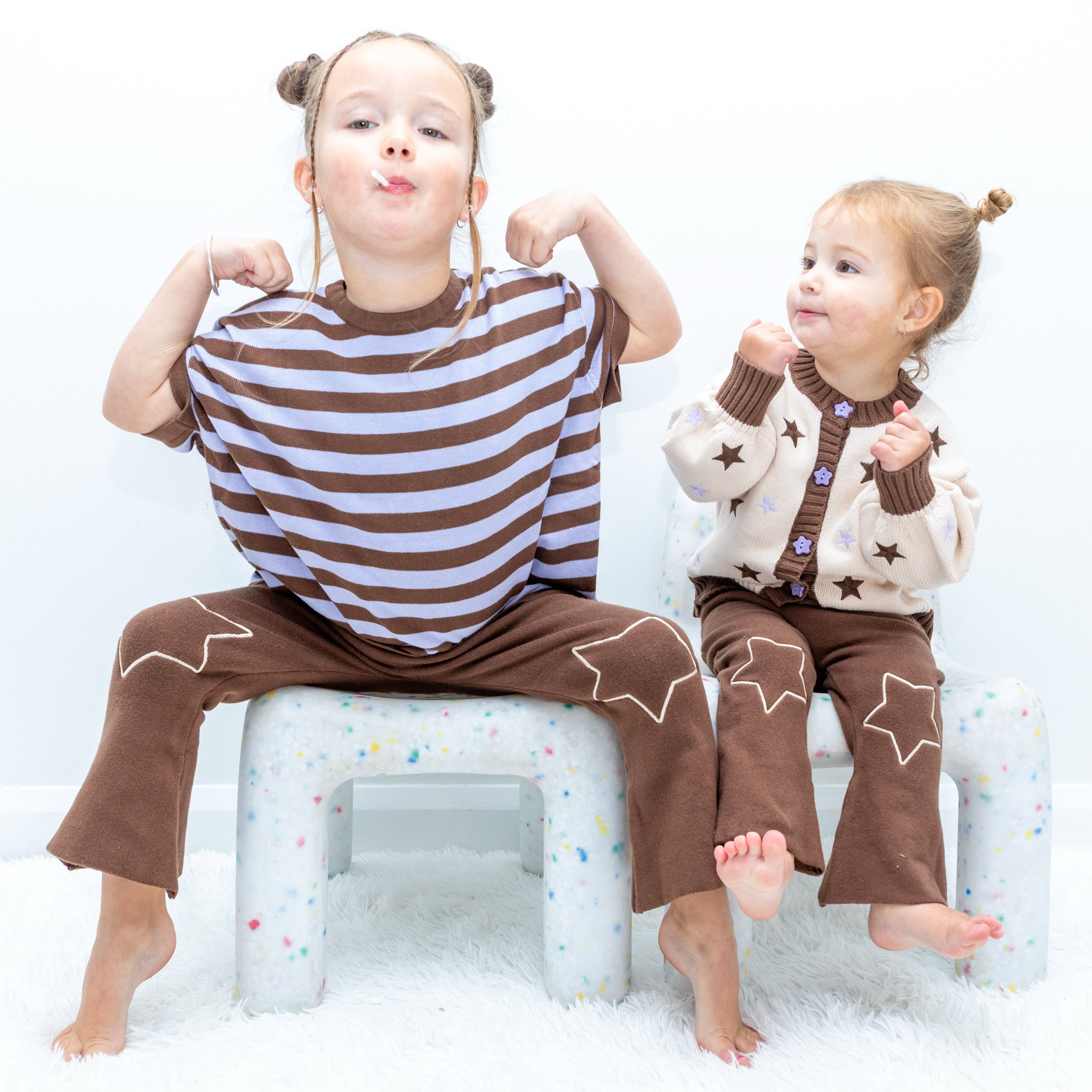 Two children in Star Gazer pieces including the Cosmic Tee, star cardigan and starry flare pants